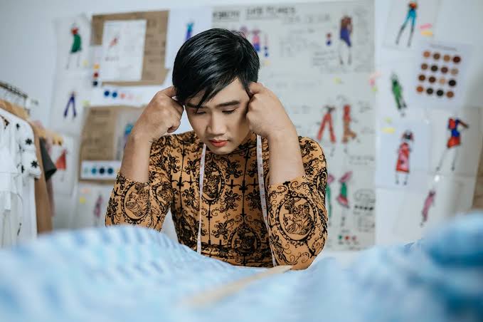 Seseorang duduk dengan tenang di dekat jendela sambil melakukan latihan pernapasan untuk membantu mengelola stres dan cara mengatasi overthinking.